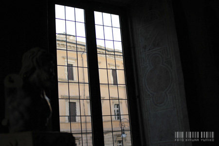 窓の外を望む:時代物のガラスでぼやけた線で浮き上がるローマ